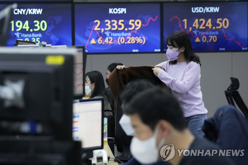 A currency trader hangs her jacket on a chair in front of screens showing the Korea Composite Stock Price Index (KOSPI) and the foreign exchange rate between the U.S. dollar and the South Korean won at the foreign exchange dealing room of the KEB Hana Bank headquarters in Seoul on Nov. 4, 2022, in this Associated Press photo. (Yonhap)