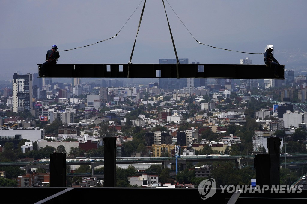 공중에 매달린 철제 빔에 앉아 휴식 중인 멕시코 근로자