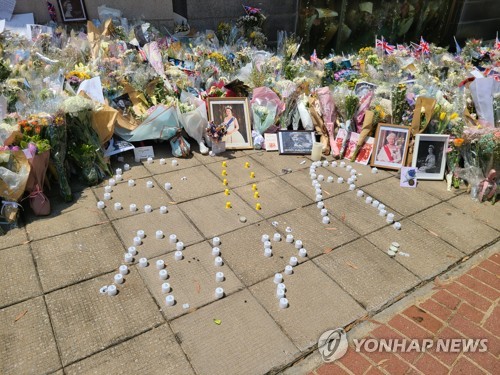 [촬영 윤고은]13일 홍콩 주재 영국 총영사관 앞에 놓인 꽃들과 여왕의 명복을 비는 촛불.