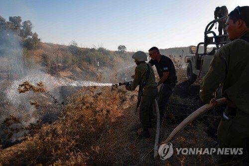 지난달 19일 이스라엘 키부츠키수핌 지역에서 이스라엘 군인들이 가자지구 팔레스타인 무장 정파 하마스가 날려보낸 인화성 물질로 인해 발생한 화재를 진압하고 있다.[AFP=연합뉴스 자료사진]