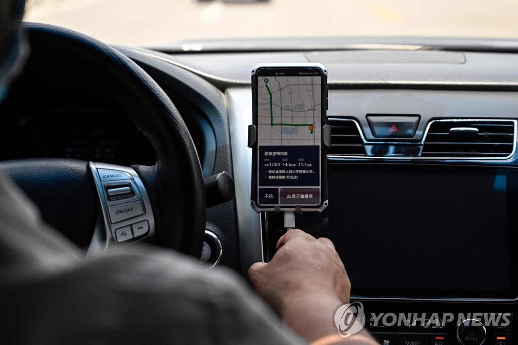 베이징에서 스마트폰으로 디디추싱 앱을 사용하는 운전기사