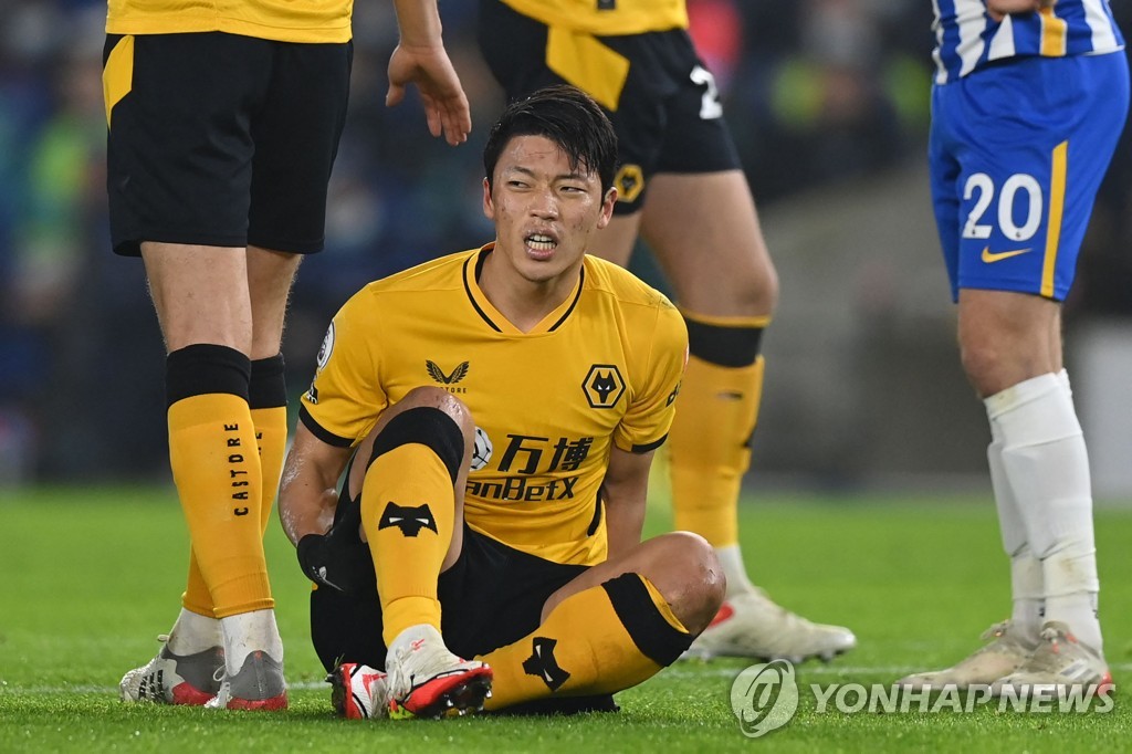 In this AFP file photo from Dec. 15, 2021, Hwang Hee-chan of Wolverhampton Wanderers grabs his right hamstring after suffering an injury during a Premier League match against Brighton & Hove Albion at American Express Community Stadium in Brighton, England. (Yonhap)