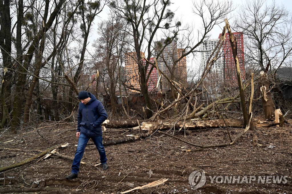 지난달 26일 러시아 미사일 공습에 부러진 나무를 지나는 한 우크라이나 남성