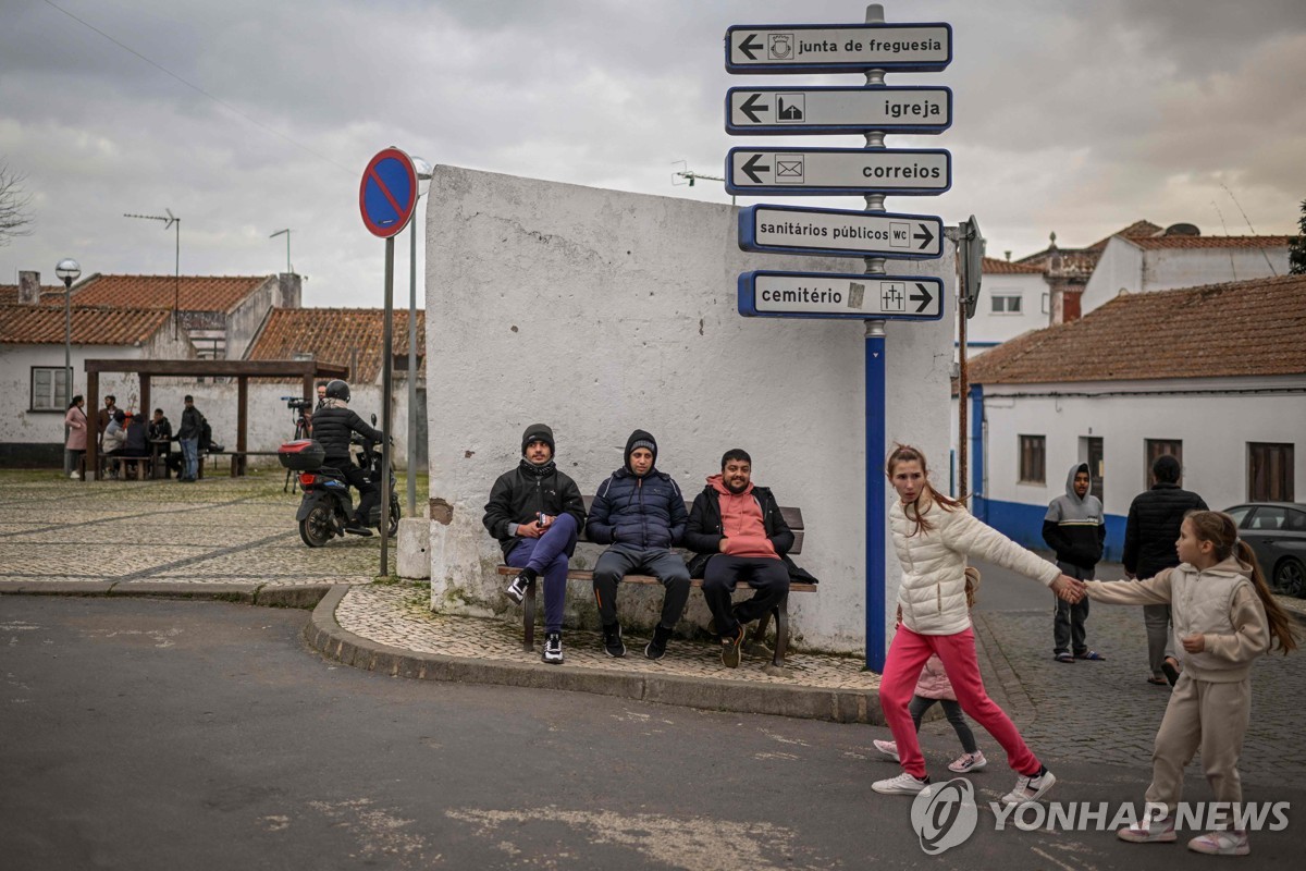 포르투갈 농촌마을 사우 테오토니우 시내에서 버스를 기다리는 아시아계 이민자들