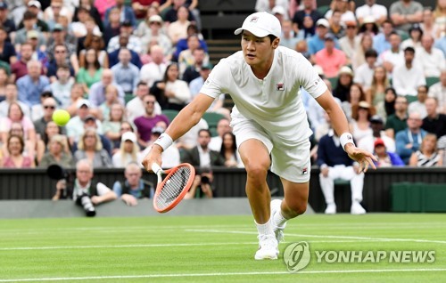 In this EPA photo, Kwon Soon-woo of South Korea hits a shot against Novak Djokovic of Serbia during their men's singles first round match at Wimbledon at All England Club in London on June 27, 2022. (Yonhap)