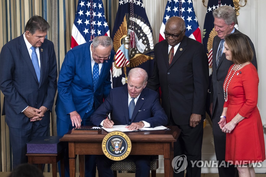 In this UPI photo from Aug. 16, 2022, U.S. President Joe Biden, surrounded by Democratic lawmakers, signs the Inflation Reduction Act in the State Dining Room of the White House in Washington. (PHOTO NOT FOR SALE) (Yonhap)