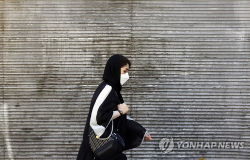 테헤란 거리를 지나치는 여성