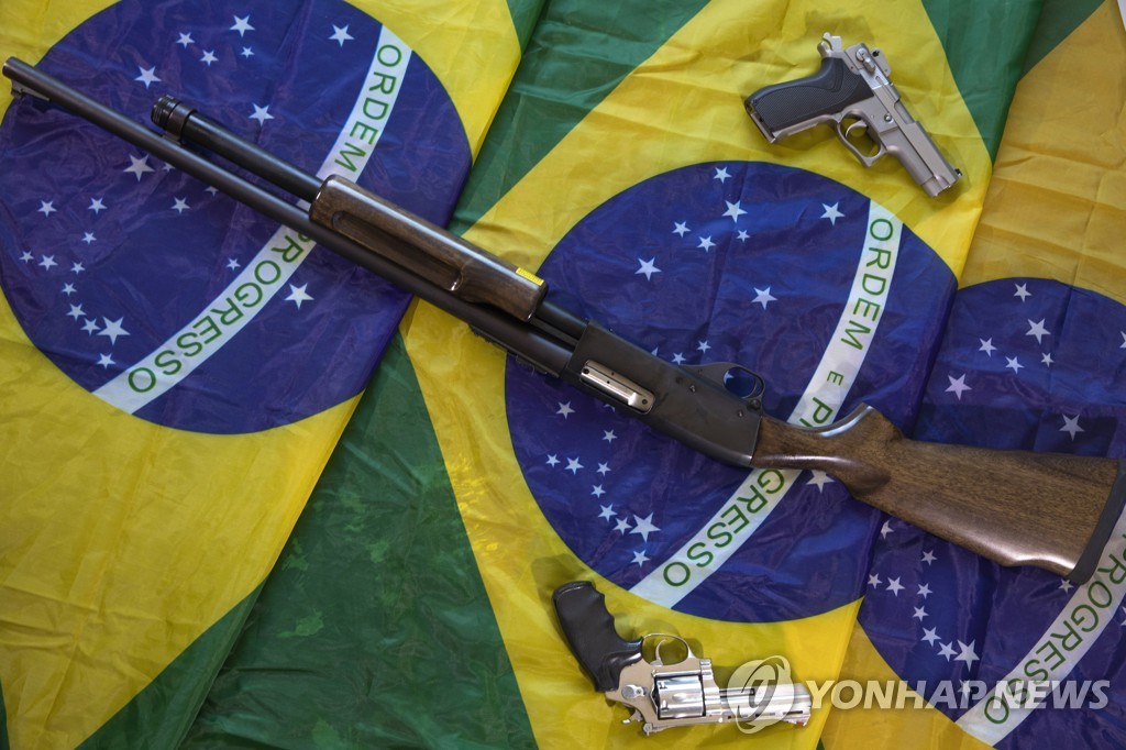 브라질 국기 위에 놓인 총기류