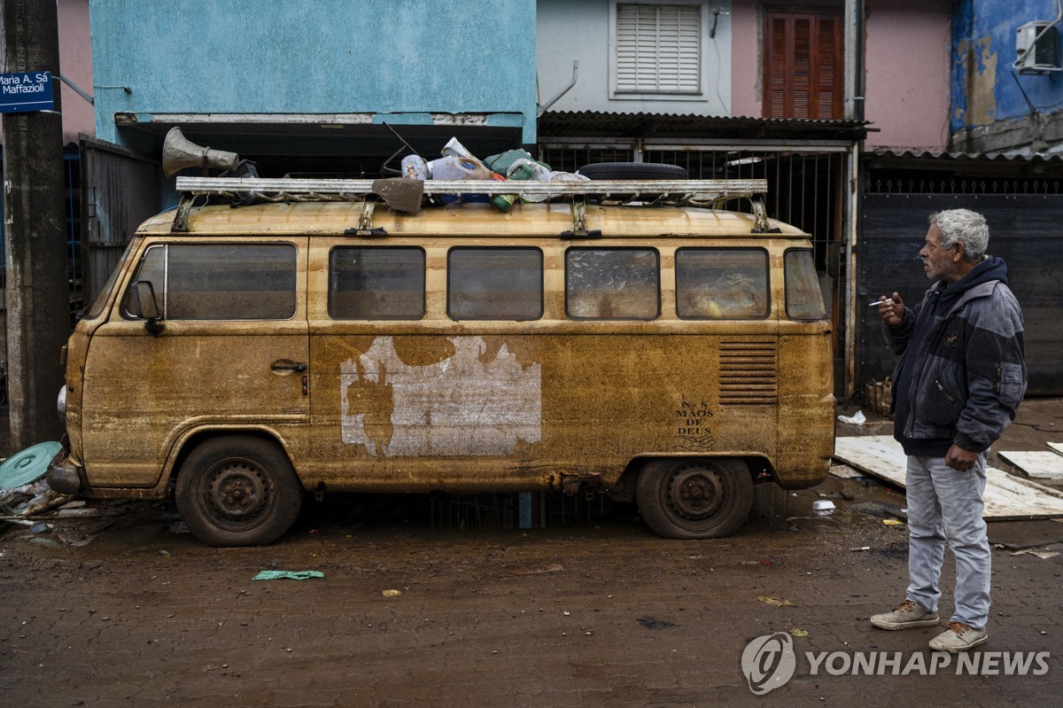 홍수 속 진흙 뒤집어 썼던 자신의 차량을 바라보는 브라질 남성