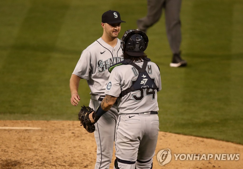 In this Getty Images file photo from Sept. 26, 2020, Walker Lockett of the Seattle Mariners (L) celebrates with his catcher Joseph Odom after a 12-3 victory over the Oakland Athletics in a Major League Baseball regular season game at RingCentral Coliseum in Oakland. (Yonhap)
