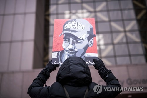 법원 앞에서 피해자의 초상을 들고 있는 시위자