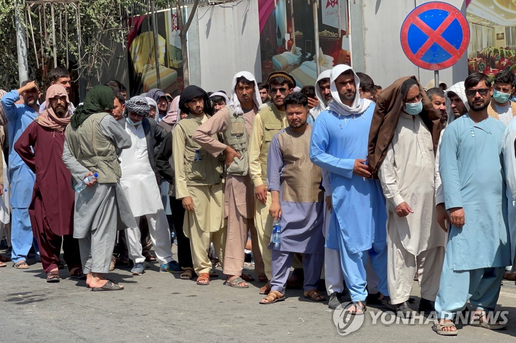 지난 1일 아프간인들이 수도 카불의 한 은행 앞에서 현금을 찾으려고 줄을 서 있다. [로이터=연합뉴스 자료사진]