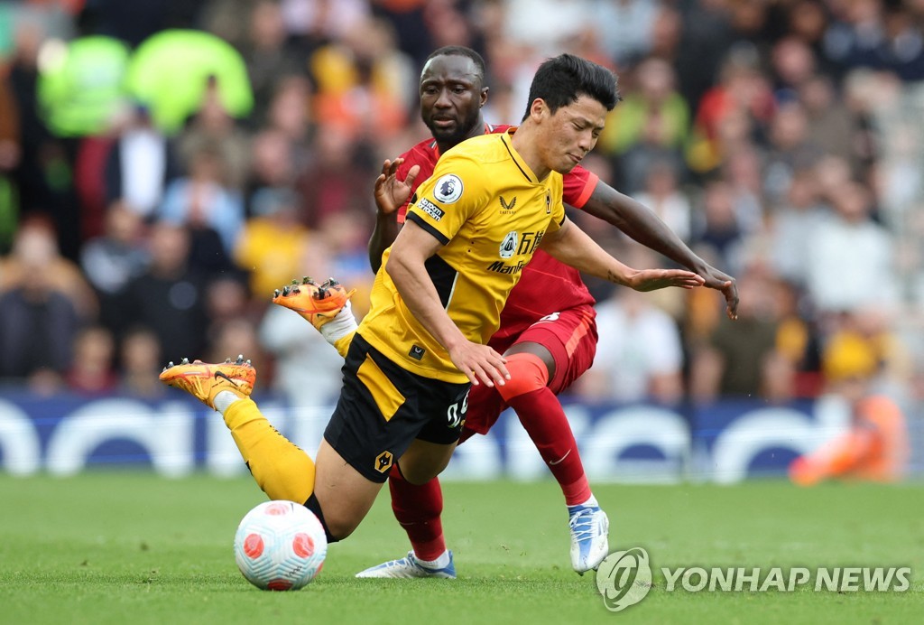 In this Reuters photo, Hwang Hee-chan of Wolverhampton Wanderers (L) is in action against Naby Keita of Liverpool during the clubs' Premier League match at Anfield in Liverpool, England, on May 22, 2022. (Yonhap)
