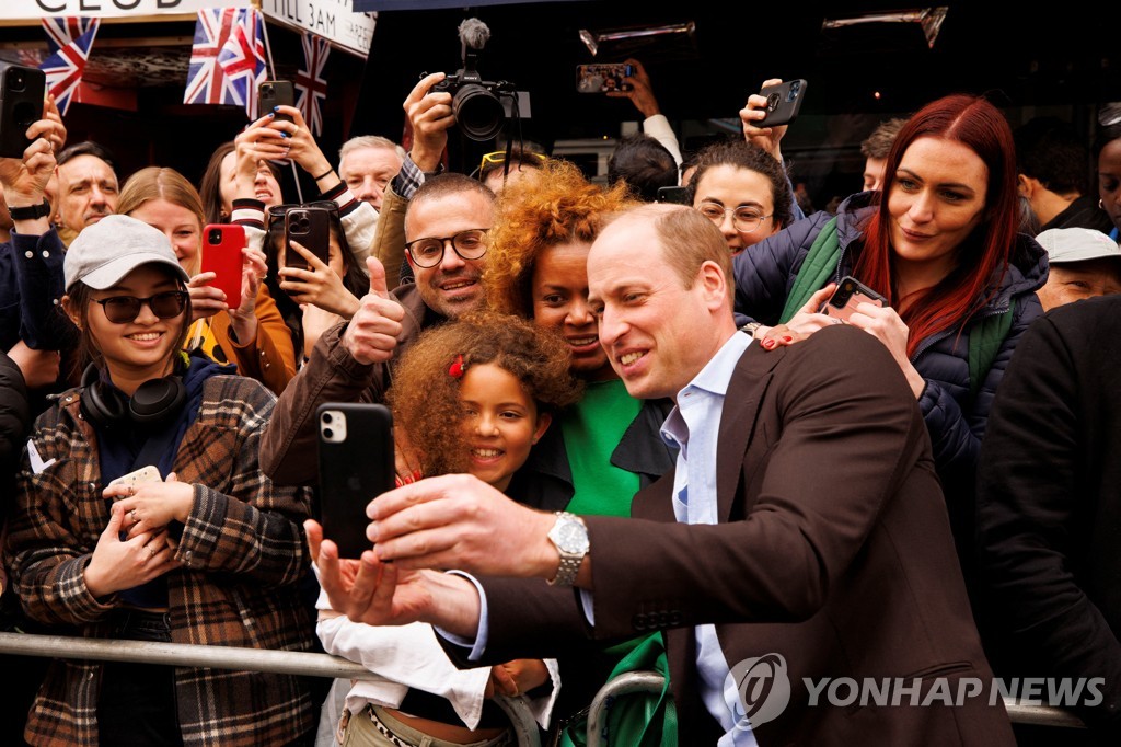 4일(현지시간) 영국 런던 소호 거리에서 왕실 팬들과 사진 찍는 윌리엄 왕세자 