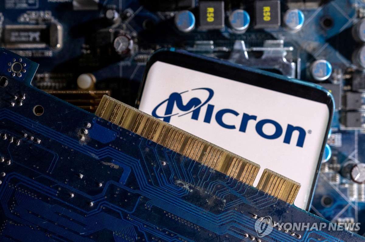 A smartphone with a displayed Micron logo is placed on a computer motherboard in this illustration released by Reuters. (Yonhap)