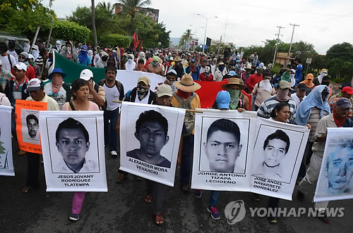 실종 대학생 43명의 사진을 앞세운 멕시코 시위대가 10일(현지시간) 게레로주(州) 아카풀코 국제공항 진입로를 점거, 출입을 차단하고 있다. (AP=연합뉴스)