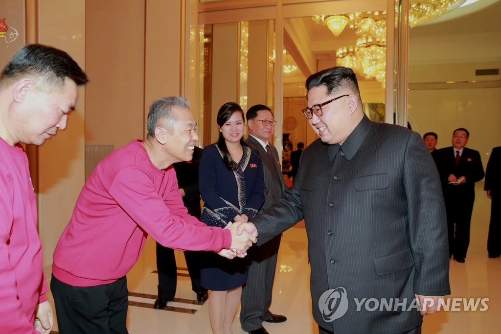 In this photo captured from the North's Korean Central TV on Feb. 13, 2018, North Korean leader Kim Jong-un (R) shakes hands with Jang Ryong-sik, chief conductor of the Samjiyon Orchestra. The North Korean art troupe staged two performances during its visit to celebrate South Korea's hosting of the PyeongChang Winter Olympics. (For Use Only in the Republic of Korea. No Redistribution) (Yonhap)