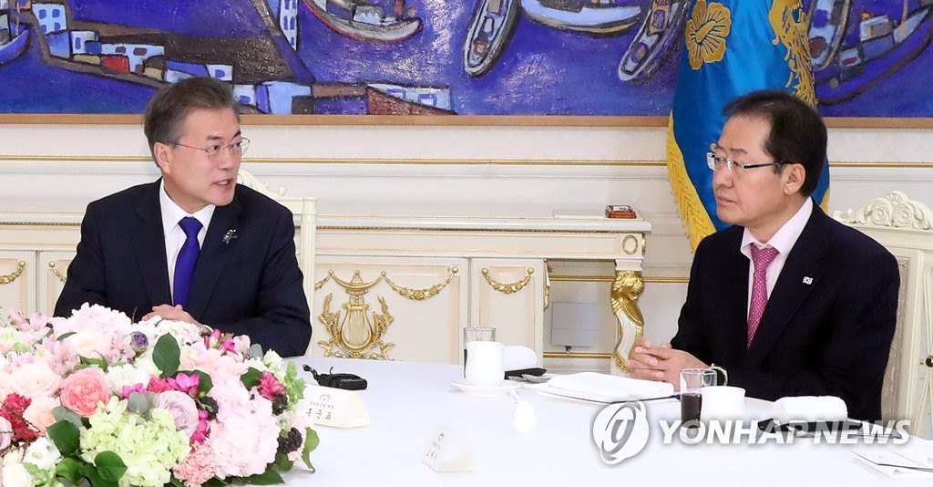 今年３月７日、青瓦台で与野党代表と会合した文大統領（左）。右は最大野党・自由韓国党の洪準杓（ホン・ジュンピョ）代表＝（聯合ニュース）