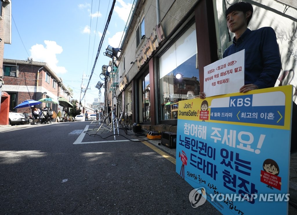 An official from Hanbit Media Labor Rights Center stages a protest to demand improved labor environments for drama crew in Seoul on Sept. 27, 2018. (Yonhap)