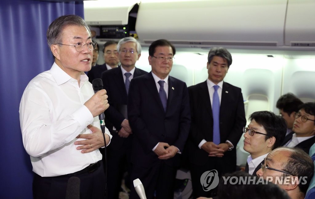 President Moon Jae-in (L) holds a press conference aboard Air Force One while en route to New Zealand following his departure from Argentina on Dec. 1, 2018. (Yonhap)