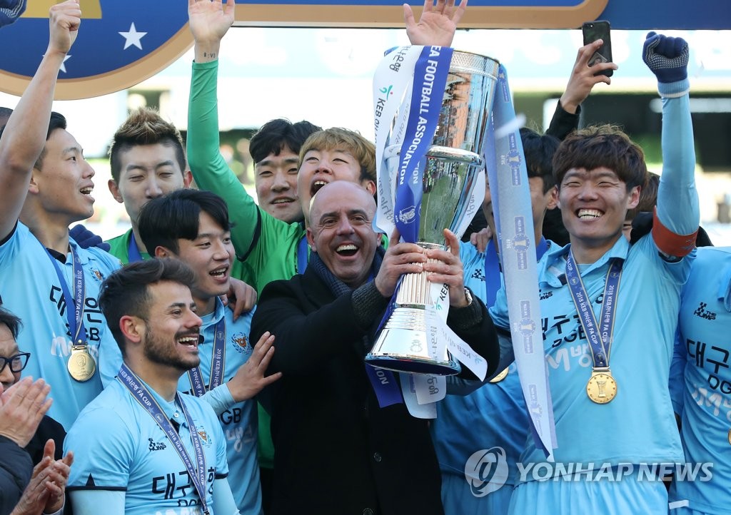 Daegu FC head coach Andre Luiz Alves Santos (C) lifts the Korea Football Association Cup champions' trophy after his side beat Ulsan Hyundai FC 5-1 on aggregate to claim the title at Daegu Stadium in Daegu on Dec. 8, 2018. (Yonhap)
