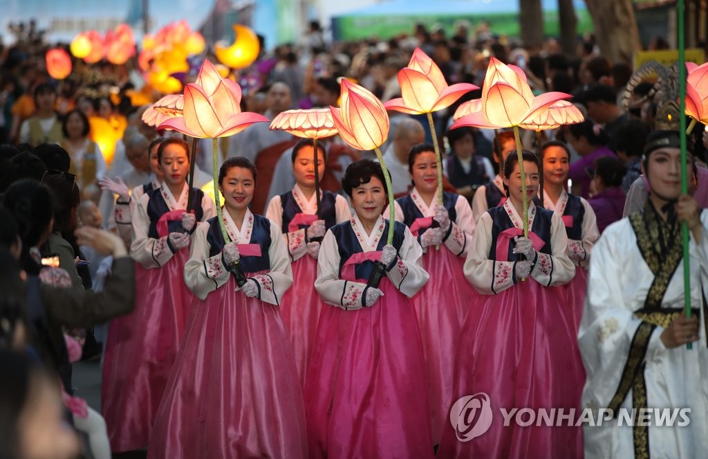 This file photo from May 5, 2019, shows participants holding lotus-shaped lanterns during a lantern lighting festival in central Seoul. (Yonhap)