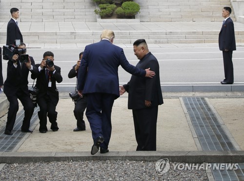 U.S. President Donald Trump (L, front) steps into the North Korean side of Panmunjom on June 30, 2019. (Yonhap)
