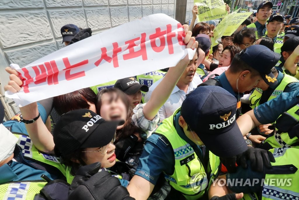 In this photo provided by the Busan Ilbo, college students are apprehended by police outside the Japanese Consulate in Busan on July 22, 2019, after they staged a sudden demonstration inside the building condemning Japan for its retaliatory measures against South Korea. (PHOTO NOT FOR SALE) (Yonhap) 