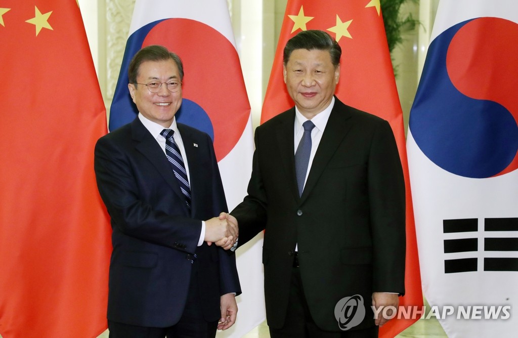 会談前、握手を交わす文大統領（左）と習主席＝２３日、北京（聯合ニュース）