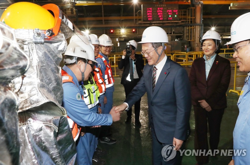 President Moon Jae-in (R) shakes hands with a worker at POSCO's smart factory in Pohang, North Gyeongsang Province, on Jan. 9, 2020. (Yonhap)