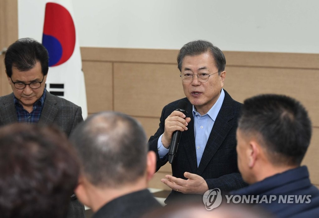 President Moon Jae-in (2nd from R) meets with residents in Jincheon and Eumseong, North Chungcheong Province, on Feb. 9, 2020, after visiting a quarantine facility in Jincheon for South Koreans who have returned from the Chinese city of Wuhan amid the new coronavirus outbreak. (Yonhap)