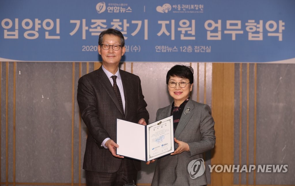 Cho Sung-boo (L), president and CEO of Yonhap News Agency, and Yoon Hye-mee, chief of the National Center for the Rights of the Child, hold a memorandum of understanding on a joint campaign to help overseas Korean adoptees find their birth families at Yonhap headquarters in central Seoul on Feb. 12, 2020. (Yonhap) 