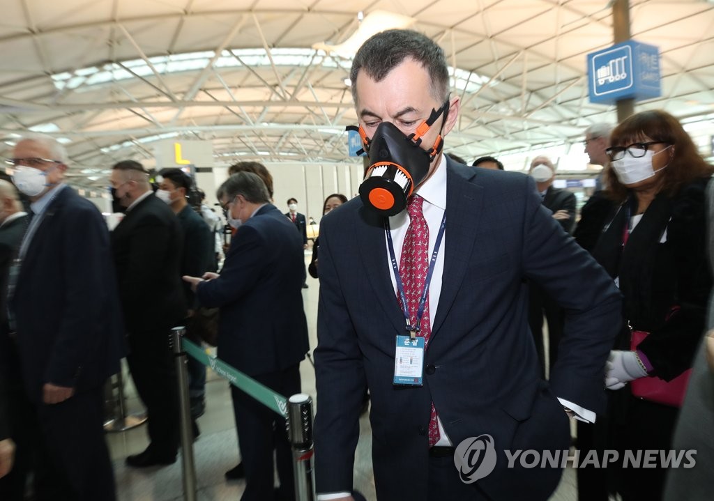 3月13日，在仁川国际机场第一航站楼出入境检疫区，各国驻韩外交使节了解出入境检疫程序。 韩联社
