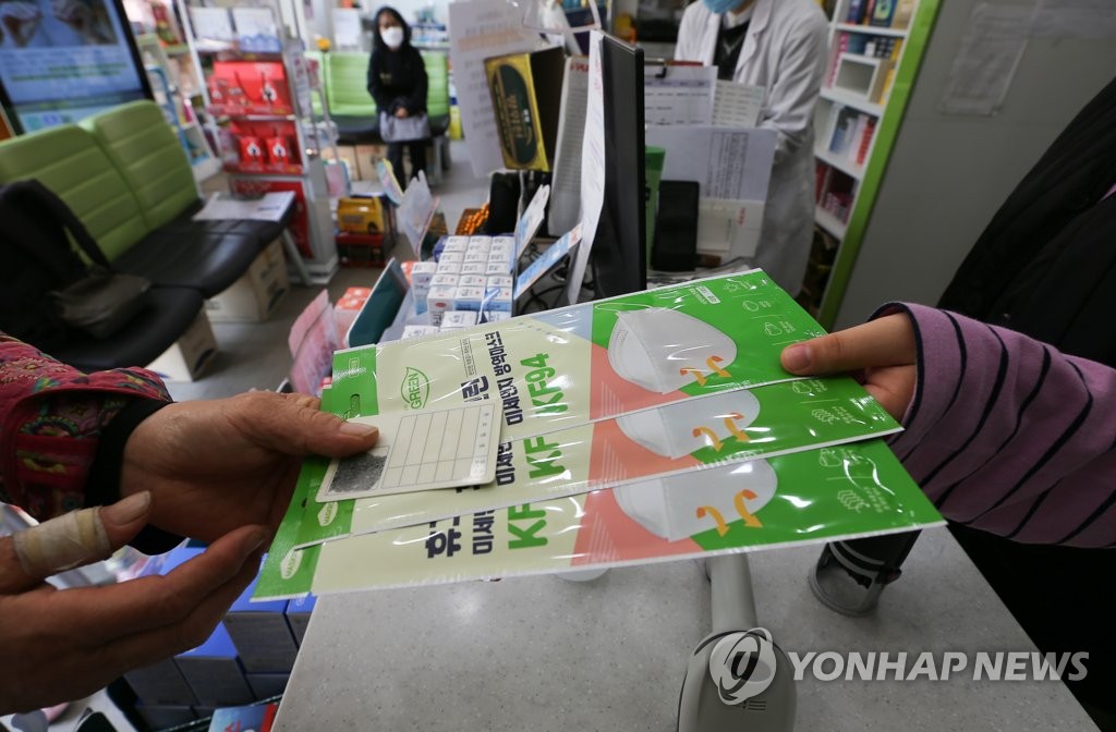 A citizen buys three masks at a drug store in Seoul on April 27, 2020. (Yonhap)