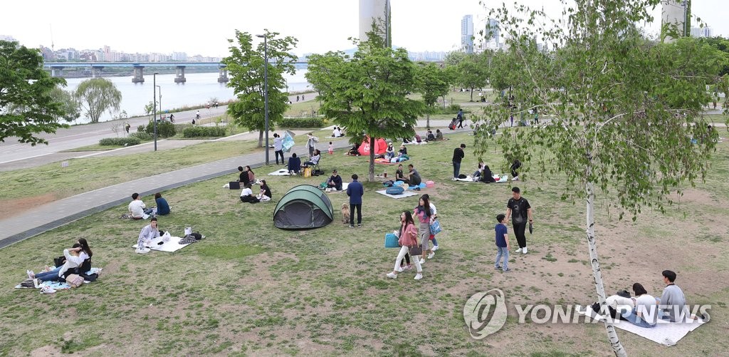 日曜日の３日、漢江沿いでピクニックを楽しむ人々＝（聯合ニュース）