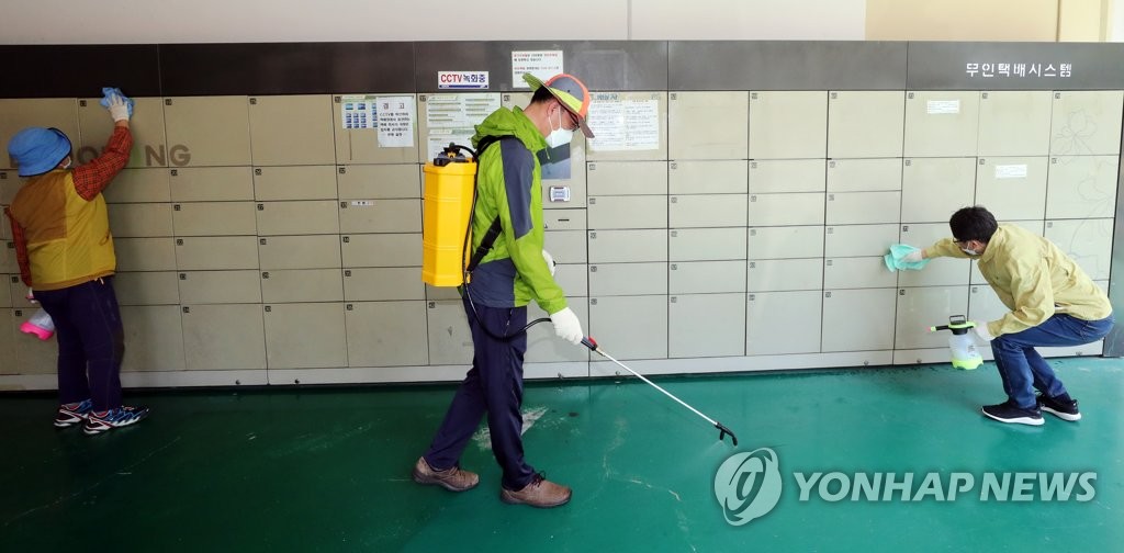 Sanitation workers disinfect delivery lockers at an apartment building in Gwangju, 330 kilometers south of Seoul, on May 28, 2020. (Yonhap)