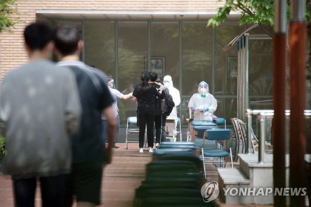 Students and teachers of a high school in northern Seoul wait in line to be tested for the new coronavirus at a makeshift clinic on June 8, 2020, after one of its students tested positive for the virus a day earlier. (Yonhap)
