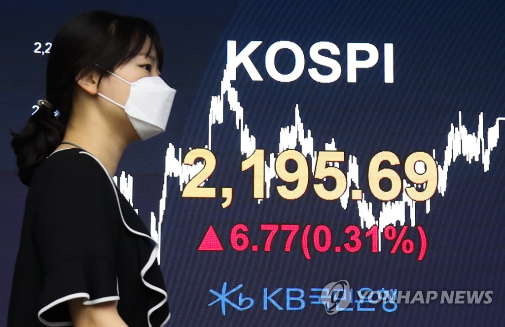 A staff member walks past an electronic signboard in the dealing room of KB Kookmin Bank in Seoul on June 10, 2020. The benchmark Korea Composite Stock Price Index (KOSPI) gained 6.77 points, or 0.31 percent, to finish at 2,195.69. (Yonhap)