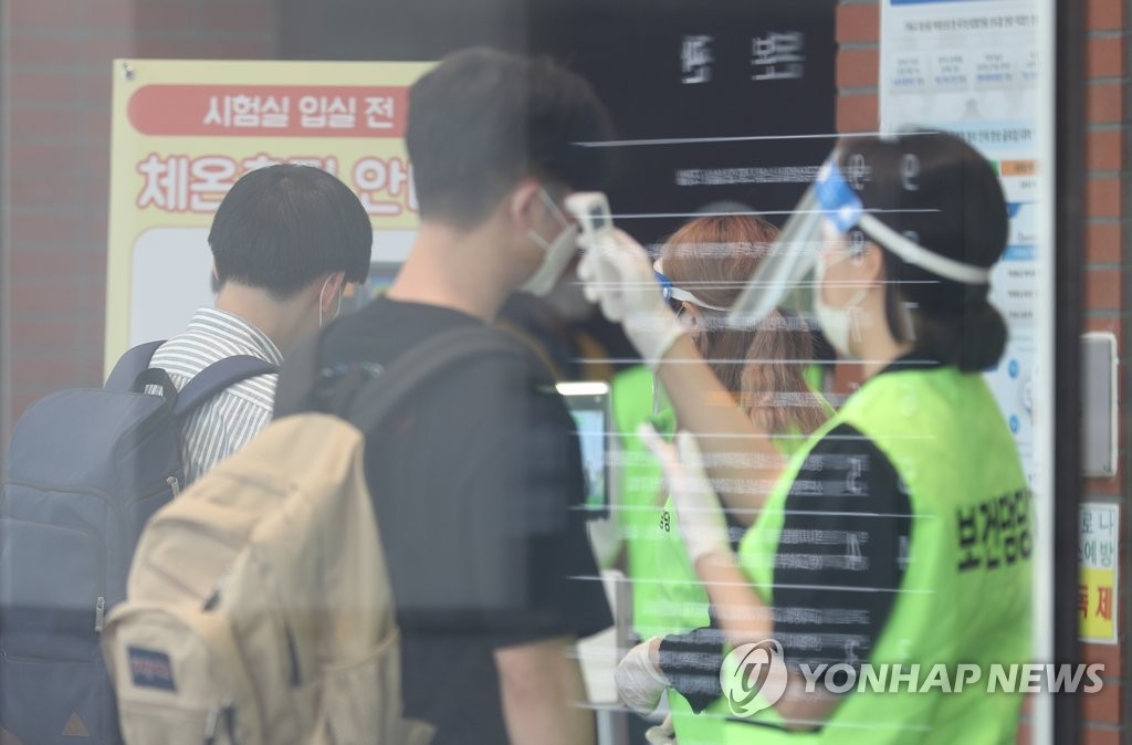 Applicants seeking to join South Korea's state-run rail operator Korea Railroad Corp. have their temperatures checked before taking an entrance test at a college in western Seoul on June 14, 2020. (Yonhap)