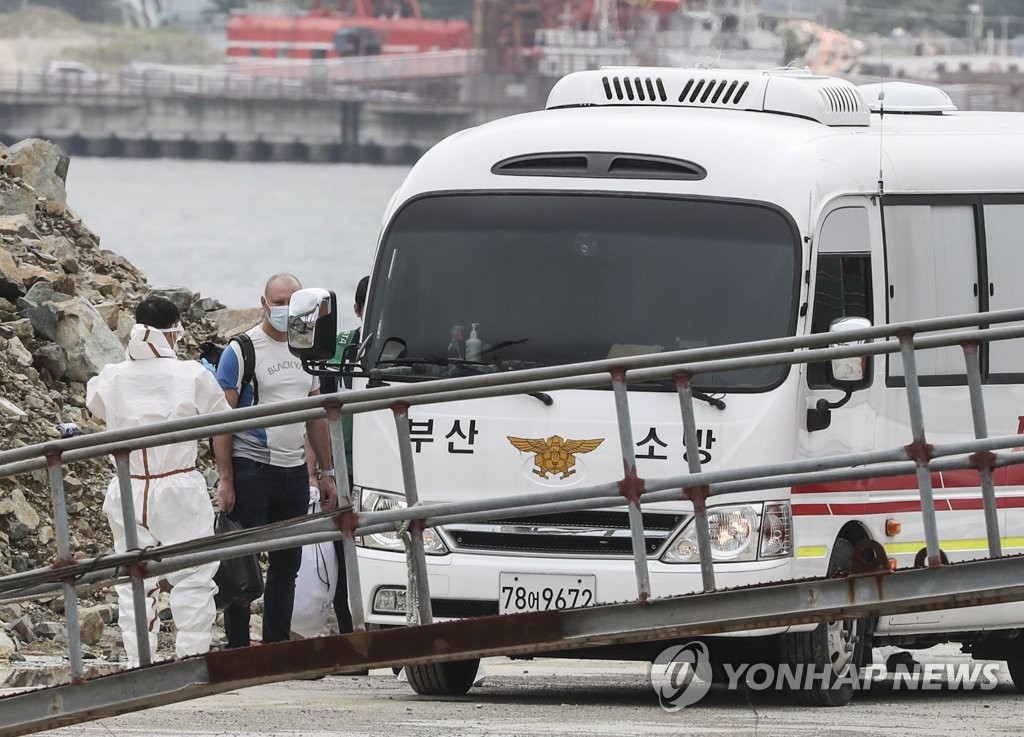 Crew members of a 7,733-ton Russian pelagic fishing boat take a fire service bus to be transported to Busan Medical Center in Busan on July 24, 2020. Of the 92 crewmen, 32 tested positive for COVID-19. (Yonhap)