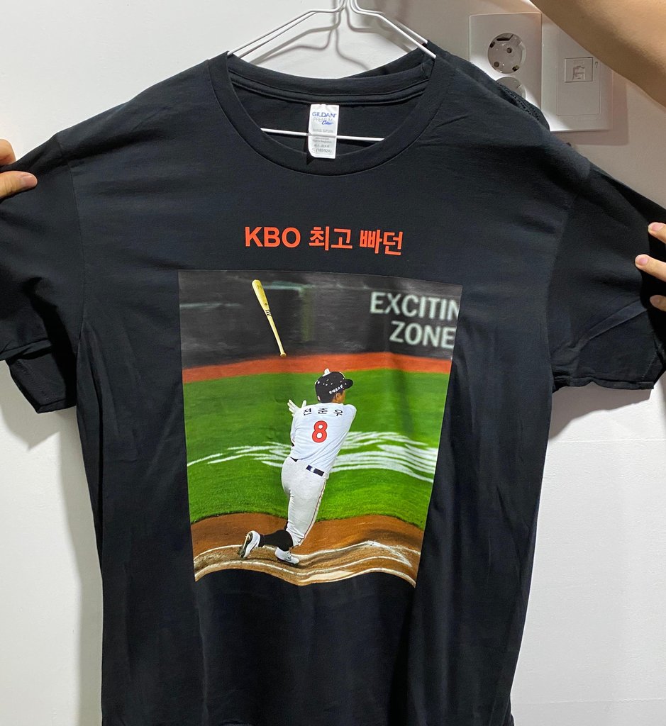 This July 29, 2020, file photo provided by the Lotte Giants shows a T-shirt produced by the Korea Baseball Organization club's pitcher Dan Straily, showing his outfielder Jeon Jun-woo. The words above the photo say, "KBO's greatest bat flip." (PHOTO NOT FOR SALE) (Yonhap)