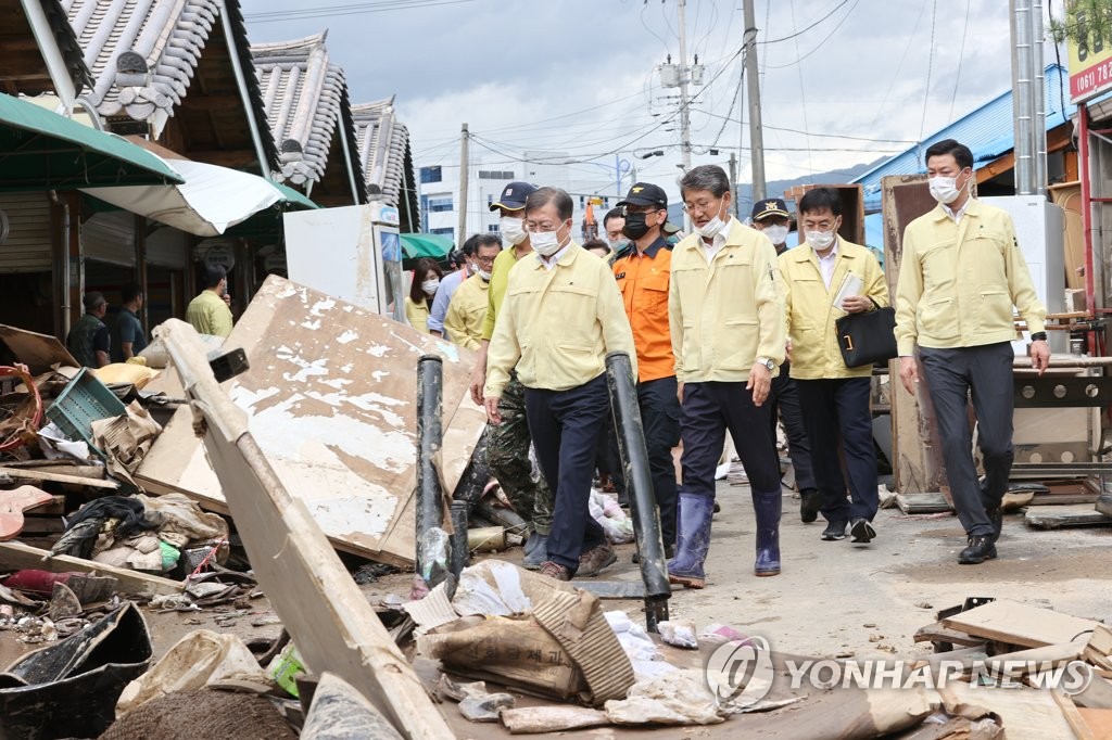 President Moon Jae-in (L, front) inspects a town damaged by heavy rains in Gurye, South Jeolla Province, on Aug. 12, 2020. (Yonhap)