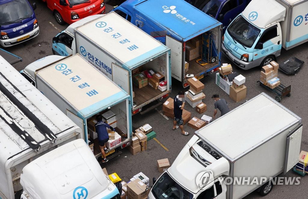 Delivery workers sort items that have to be delivered at a logistics center in Seoul on Aug. 13, 2020, a day before the industry went on a one-day special holiday. (Yonhap)