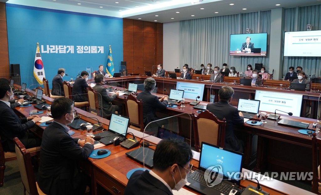 President Moon Jae-in's weekly meeting with senior secretaries is under way at Cheong Wa Dae in Seoul on Aug. 24, 2020, with attendees seated apart with plastic partitions on the desks. (Yonhap)
