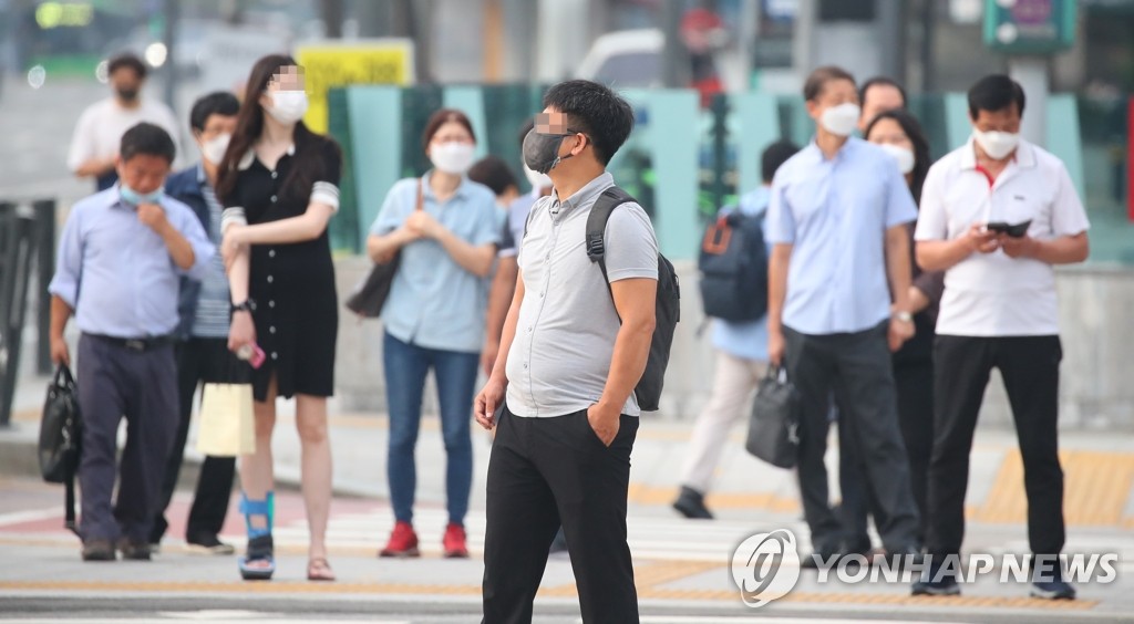 Commuters wearing protective masks wait at a pedestrian crossing in central Seoul on Aug. 25, 2020. (Yonhap)