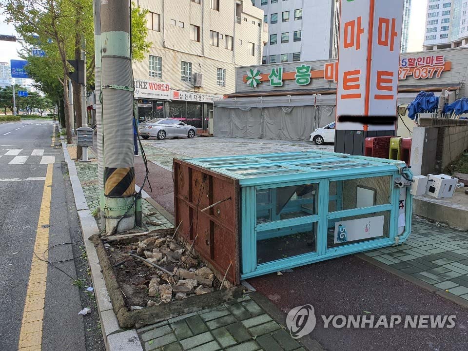 A toppled phone booth lies across the sidewalk in the southeastern city of Ulsan due to strong winds from Typhoon Maysak on Sept. 3, 2020. (Yonhap)