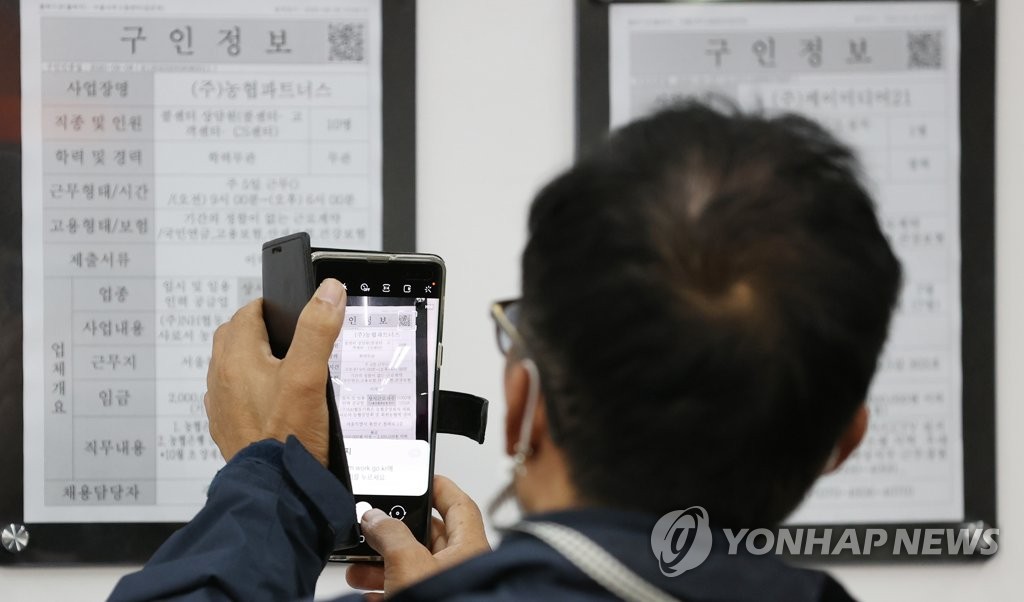 A job seeker looks at information on job positions at a job center in Seoul. (Yonhap)