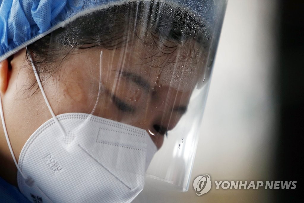 A medical staffer drenched in sweat works at a makeshift clinic on Sept. 9, 2020, in this photo released by the Buk Ward of Gwangju, 320 kilometers south of Seoul. (PHOTO NOT FOR SALE) (Yonhap) 