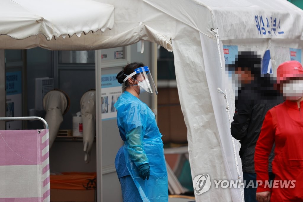 A health official helps visitors to a screening station at the National Medical Center in Seoul on Nov. 6, 2020. (Yonhap)