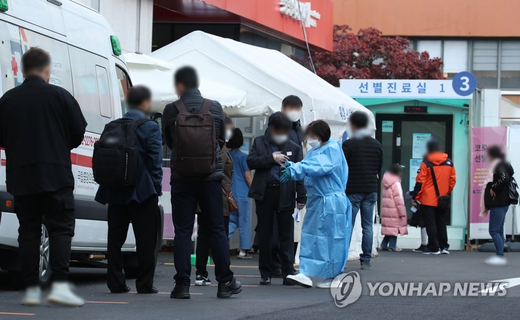 Visitors waits to receive COVID-19 test at a clinic in central Seoul on Nov. 11, 2020. (Yonhap)